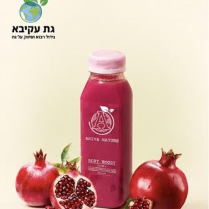 Pink juice bottle with a white label, surrounded by whole and halved pomegranates on a light background.